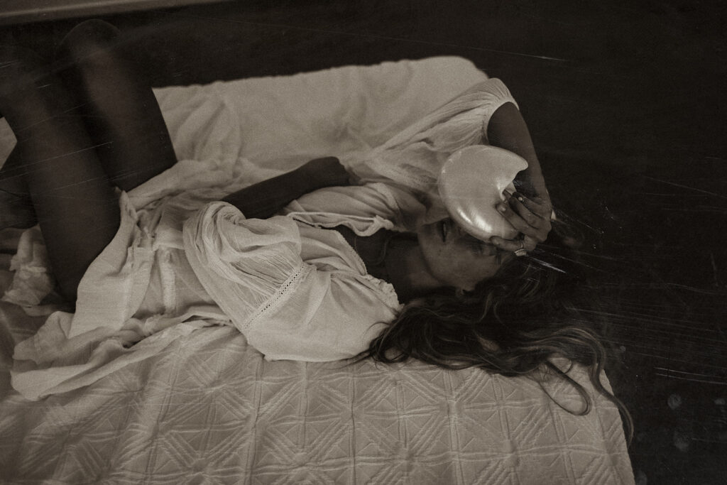 Black and white photograph of a woman lying on a bed, used as blog decoration for a photography business