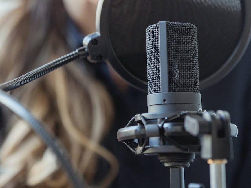 happy woman smiling while recording voice with microphone